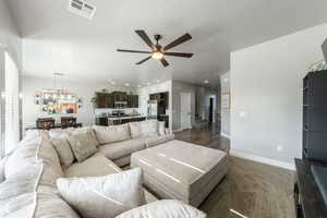 Living area with stairway, a ceiling fan, baseboards, visible vents, and recessed lighting