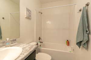 Full bathroom with vanity, toilet, and tiled shower / bath