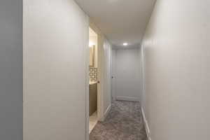 Hall with carpet flooring and a textured ceiling