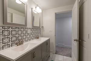 Bathroom featuring tile patterned flooring, a textured ceiling, vanity, and tasteful backsplash