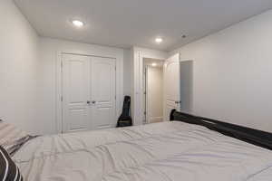 Bedroom with a textured ceiling and a closet