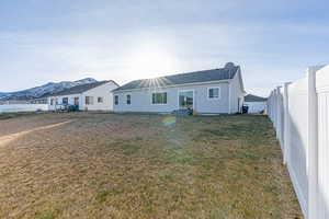 Rear view of property with a lawn and a mountain view