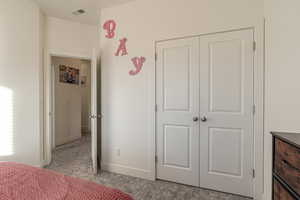 Bedroom featuring a closet and light colored carpet