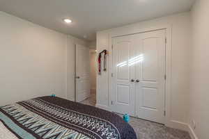 Carpeted bedroom featuring a closet