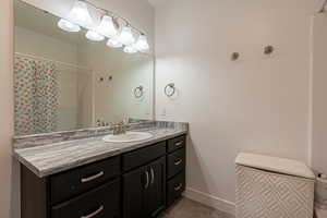 Bathroom with tile patterned floors, a shower with curtain, and vanity