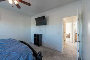 Carpeted bedroom with ceiling fan