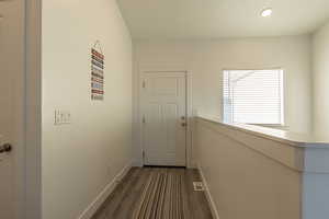 Hallway with dark hardwood / wood-style floors