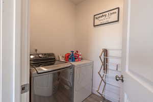 Laundry area with hardwood / wood-style flooring and independent washer and dryer