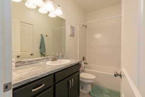 Full bathroom with tile patterned flooring, shower / bathing tub combination, vanity, and toilet