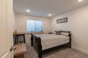 Bedroom featuring dark carpet and a textured ceiling