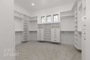 Walk in closet featuring light colored carpet