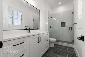 Bathroom with vanity, toilet, and a shower with door