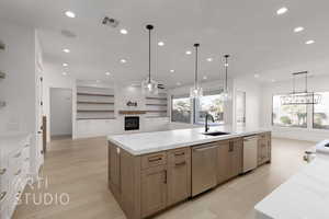 Kitchen with a wealth of natural light, a large fireplace, sink, pendant lighting, and dishwasher