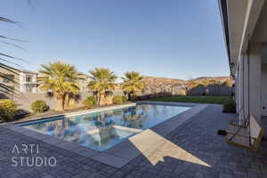 View of swimming pool featuring a mountain view, a yard, and a patio