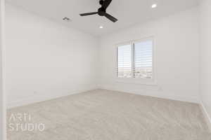 Carpeted spare room featuring ceiling fan