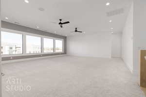 Unfurnished room with ceiling fan and light carpet