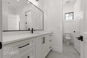 Bathroom with tile patterned floors, vanity, and toilet