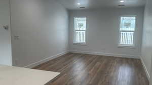 Unfurnished room with a healthy amount of sunlight and dark hardwood / wood-style floors