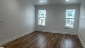 Empty room featuring dark hardwood / wood-style floors