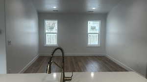 Spare room featuring dark wood-type flooring and a wealth of natural light