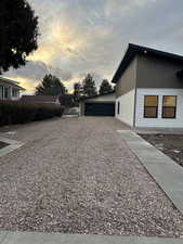 Property exterior at dusk featuring a garage and an outdoor structure