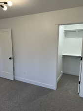 Carpeted empty room with a textured ceiling