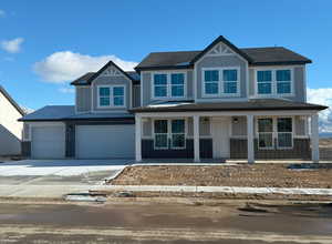 Craftsman-style home featuring covered porch and a garage