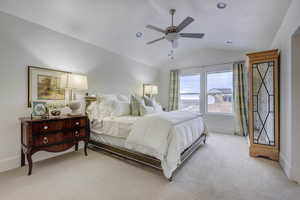 Bedroom featuring light carpet, ceiling fan, and lofted ceiling