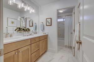 Bathroom featuring shower / bath combination with curtain and vanity