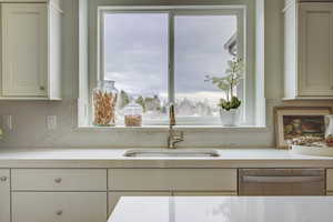 Kitchen with decorative backsplash, dishwasher, sink, and a healthy amount of sunlight