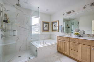 Bathroom featuring separate shower and tub and vanity