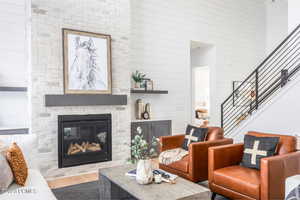 Living room featuring a fireplace, a high ceiling, and hardwood / wood-style flooring