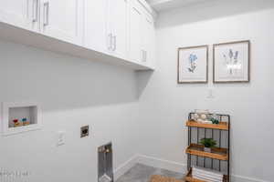 Laundry room with cabinets, hookup for a washing machine, and hookup for an electric dryer