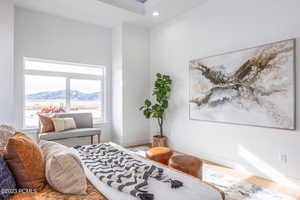 Bedroom with a mountain view, hardwood / wood-style floors, and multiple windows