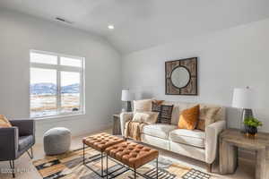 Carpeted living room with a mountain view and vaulted ceiling