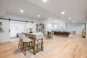 Dining room featuring light wood-type flooring and a barn door