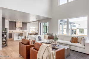 Living room with plenty of natural light, a high ceiling, and light wood-type flooring