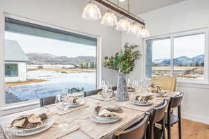 Dining space featuring hardwood / wood-style floors, a mountain view, and a healthy amount of sunlight