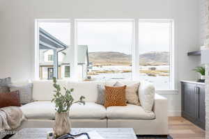 Living room featuring a mountain view, light hardwood / wood-style flooring, and a healthy amount of sunlight