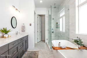 Bathroom with plus walk in shower, vanity, tile patterned floors, and a wealth of natural light