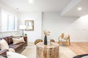 Living room featuring light hardwood / wood-style floors and wooden walls