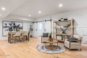 Living area featuring a barn door and light hardwood / wood-style flooring