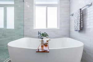 Bathroom with a tub to relax in and tile walls