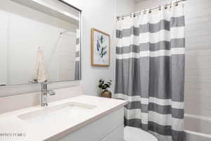 Full bathroom with vanity, toilet, and shower / bathtub combination with curtain