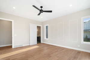 Unfurnished bedroom with light hardwood / wood-style floors, ensuite bath, and ceiling fan