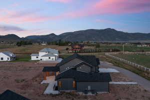 Aerial view at dusk featuring a mountain view and a rural view