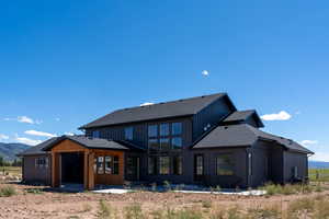 Rear view of property with a mountain view and a patio