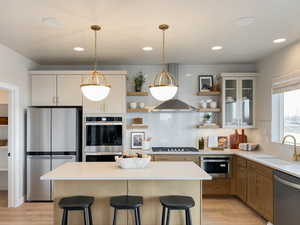 Kitchen featuring a kitchen breakfast bar, a center island, stainless steel appliances, and sink