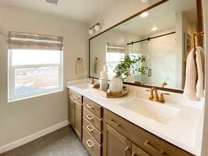 Bathroom featuring vanity and a shower with door