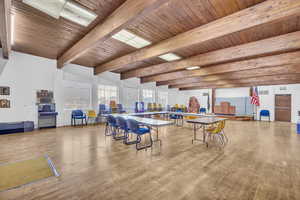 Dining room with hardwood / wood-style floors, vaulted ceiling with beams, and wooden ceiling